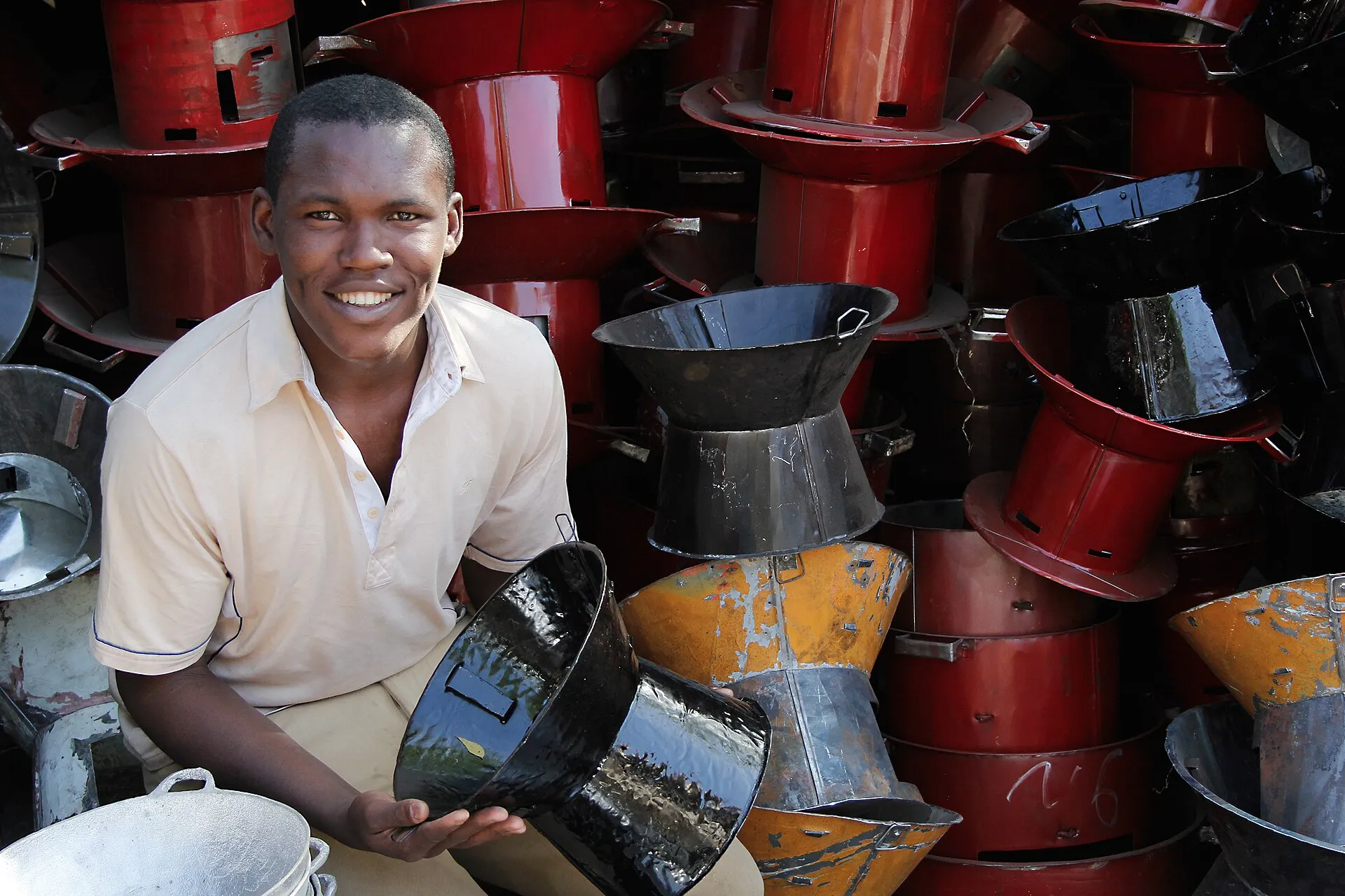 A clean cookstove maker with his stoves in his workshop